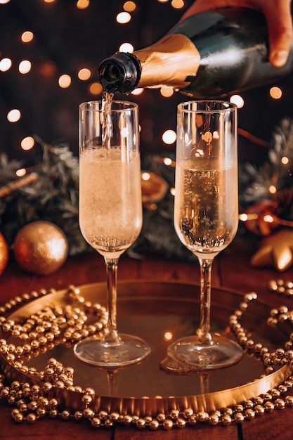 Twee glazen champagne onder kerstverlichting