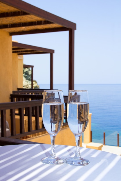 Twee glazen champagne op balkon met zeezicht