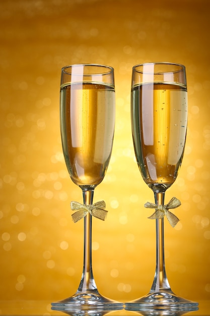 Twee glazen champagne op lichte achtergrond met verlichting