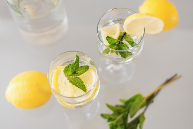 Twee glazen cocktail met citroen en munt bovenaanzicht Limonade met kruiden en fruit