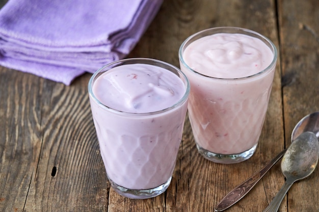 Twee glazen fruityoghurt op een houten lijst