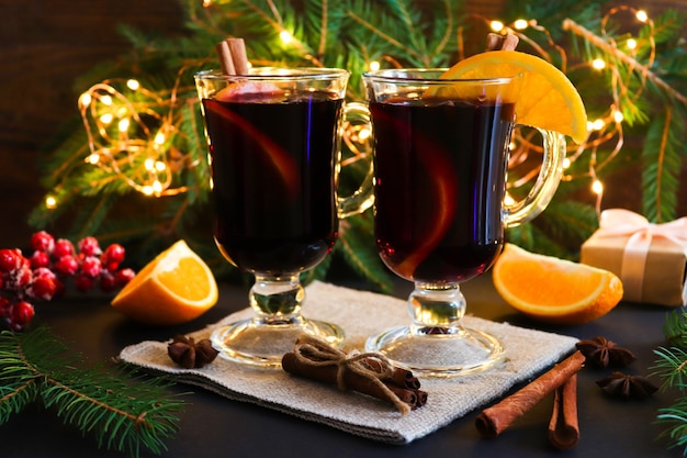 Twee glazen glühwein, kaneel en sinaasappels op feestelijke Kerstmis