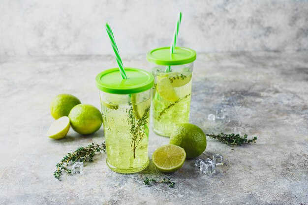 Twee glazen limoenlimonade met tijm en ijs