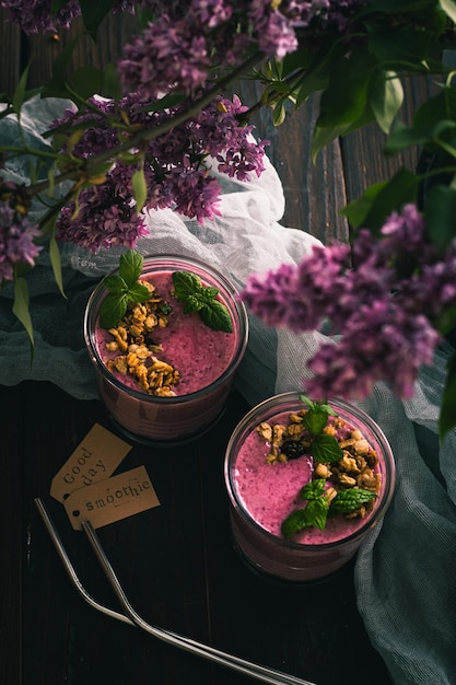 Twee glazen met bramen smoothies op tafel in het zonlicht