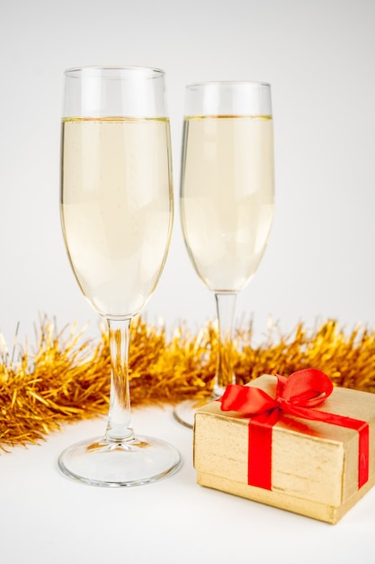 Twee glazen met champagne en gouden geschenkdoos