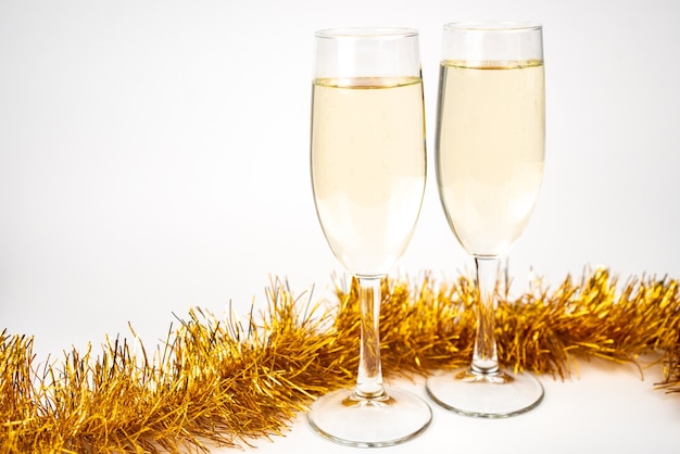 Twee glazen met champagne en gouden kerstklatergoud
