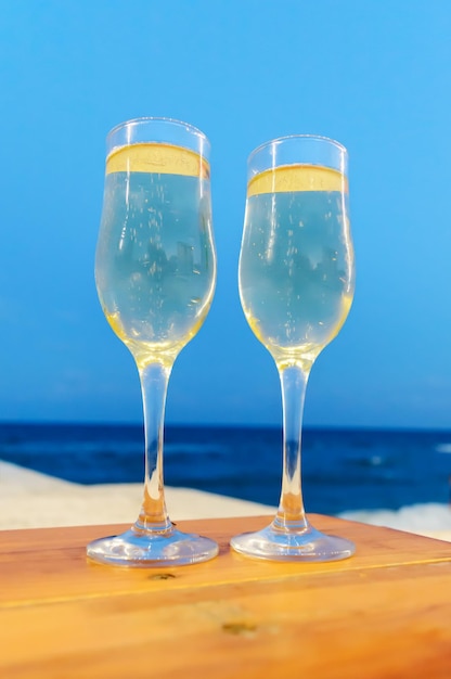 Twee glazen met champagne op het strand klaar voor een toast Verticale weergave