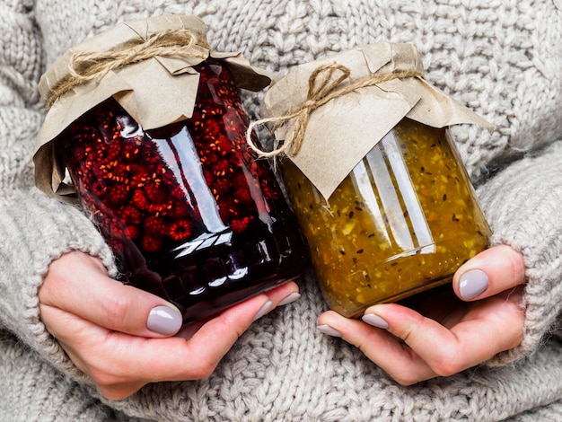 Twee glazen potten met jam in de handen van een meisje