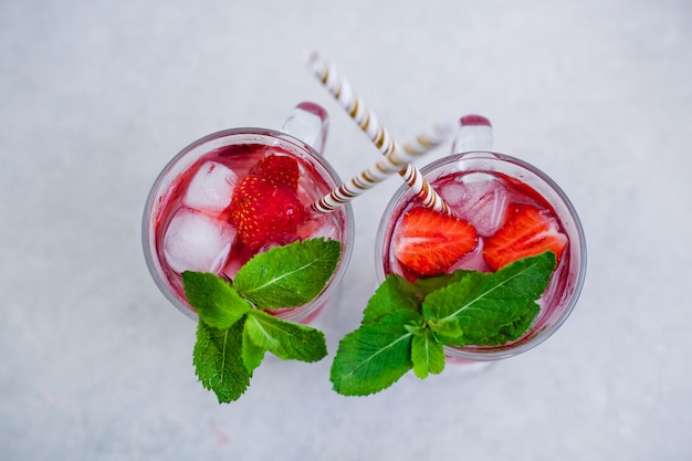 Twee glazen van de zomeraardbeidrank met rietjes