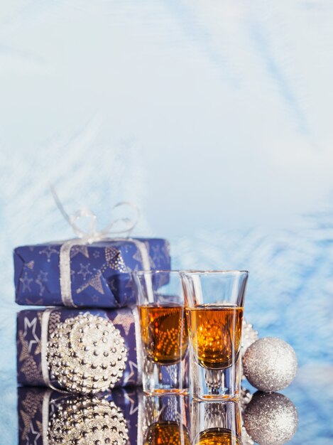 Twee glazen whisky of bourbon met kerstversiering op een lichte bokeh achtergrond. Nieuwjaar, Kerstmis en wintervakantie whisky humeur concept