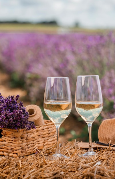 Twee glazen witte wijn in een lavendelveld in Provance Violette bloemen op de achtergrond