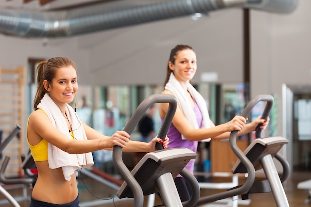 Twee glimlachende vrouwen die in een gymnastiek uitwerken