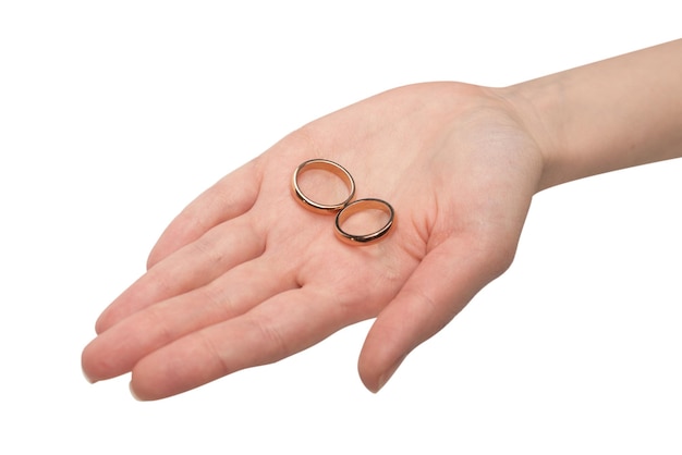 Twee gouden ringen in de hand van een vrouw geïsoleerd op een witte background
