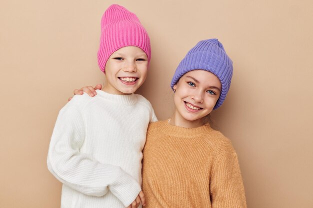 Twee grappige kleine meisjes in kleurrijke hoeden poseren