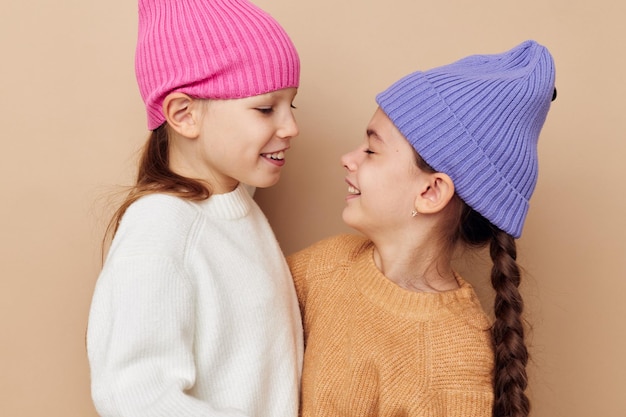 Twee grappige meisjes knuffelen poseren kleurrijke hoeden