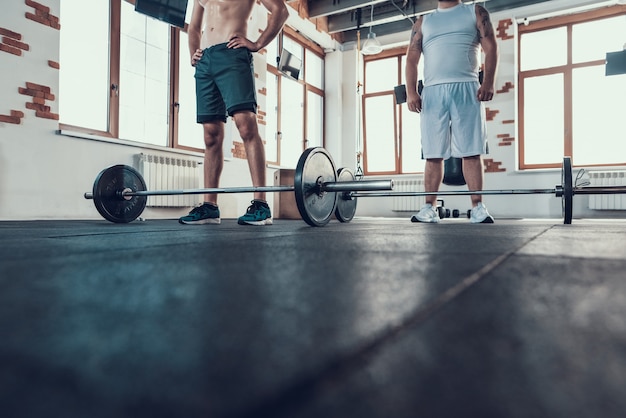 Twee grote jongens staan in de sportschool voor de tralies.