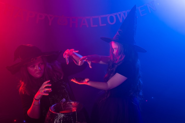 Twee halloween-heksen die magie maken in halloween-nachtmagische vakanties en mystiek concept