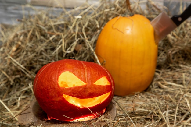 Twee halloween-pompoenen liggen op hooimes zit vast in gele pompoen Licht binnenkant van jackolantern