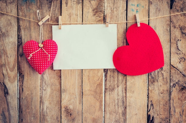 Foto twee hart opknoping en papier op waslijn en touw met houten achtergrond