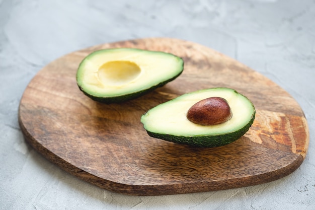 Twee helften van avocado op een houten bord