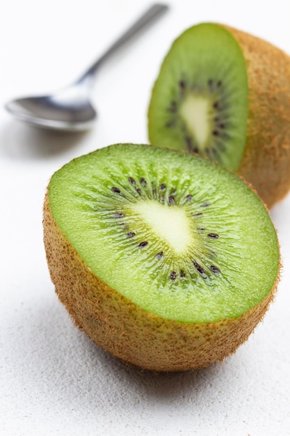 Twee helften van de kiwi en lepel Close-up Bovenaanzicht Witte achtergrond