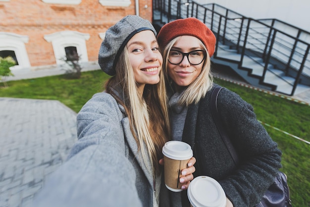 Twee hipster-vriendinnen die een zelffoto maken voor sociale netwerken in stedelijke stadsachtergrondvriendschap