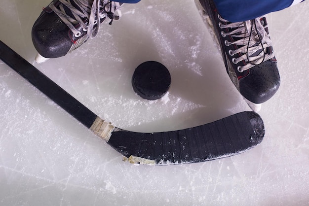 Foto twee hockeysticks en puck op ijs, start van het spel, competitieconcept in het bedrijfsleven, bovenaanzicht