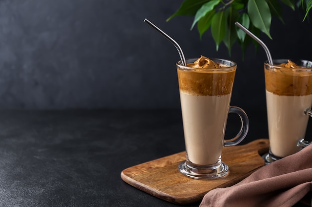 Foto twee hoge glazen met dalgona koffie op een donkere ruimte