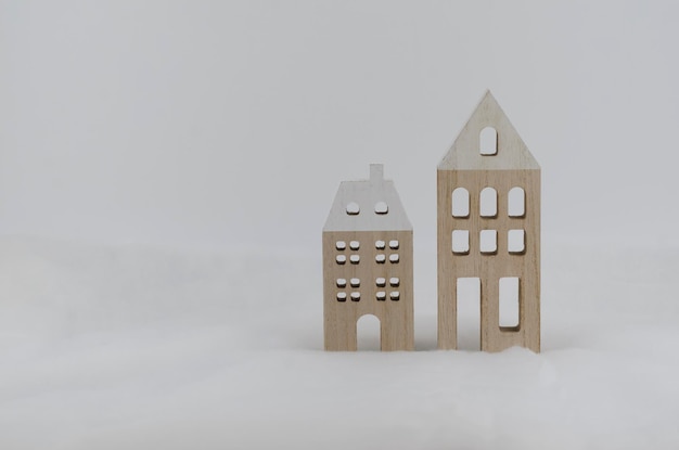 Foto twee houten huizen staan in de sneeuw concept minimalistische kerstkaart milieuvriendelijk speelgoed