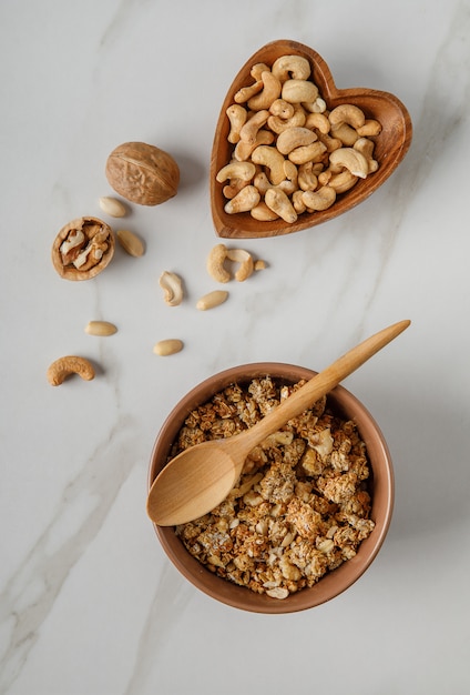 Twee houten kommen muesli op witte marmeren tafel.