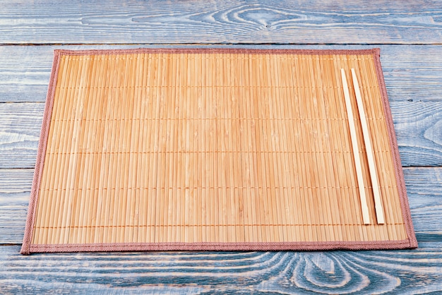 Foto twee houten stokjes op een bamboe mat