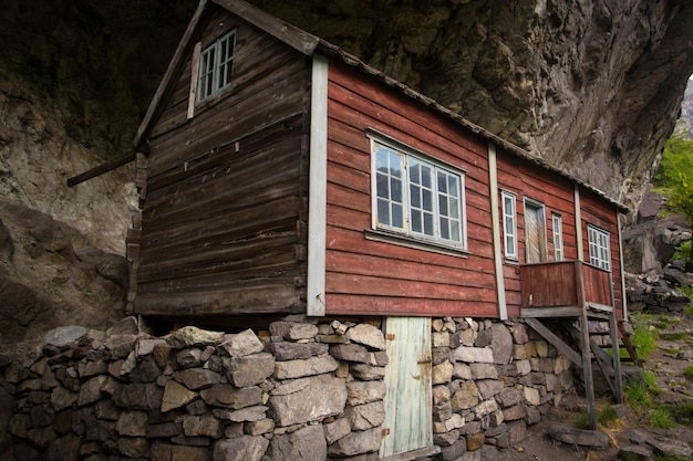 Twee huizen van oude nederzetting onder de rots Helleren, Jossingfjord, Stavanger, Zuid-Noorwegen