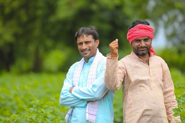 Twee Indiase boeren staan op katoenlandbouwgebied.