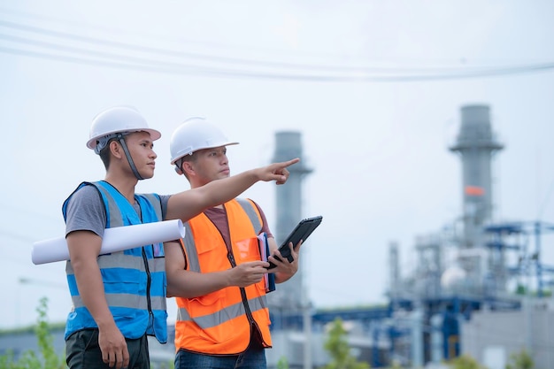 Twee ingenieur aan het werk bij energiecentraleWerk gelukkig samen Help elkaar het probleem te analyseren Raadpleeg over ontwikkelingsrichtlijnen