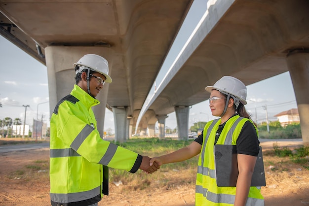 Twee ingenieurs bespreken over werk op de plaats van een grote brug in aanbouw Management consulting mensen discussie met ingenieurs over de voortgang en bouwplanning van de snelweg