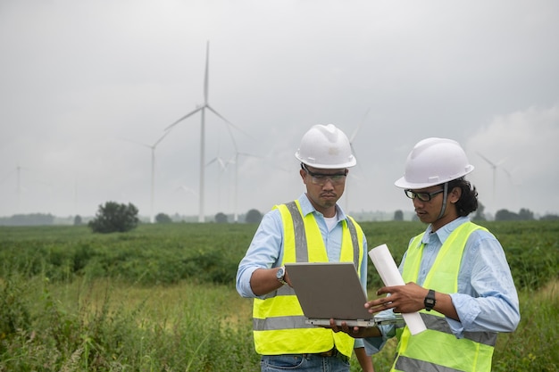 Twee ingenieurs werken en houden het rapport vast bij het Power Generator Station van het windturbinepark op mensen uit bergThailand