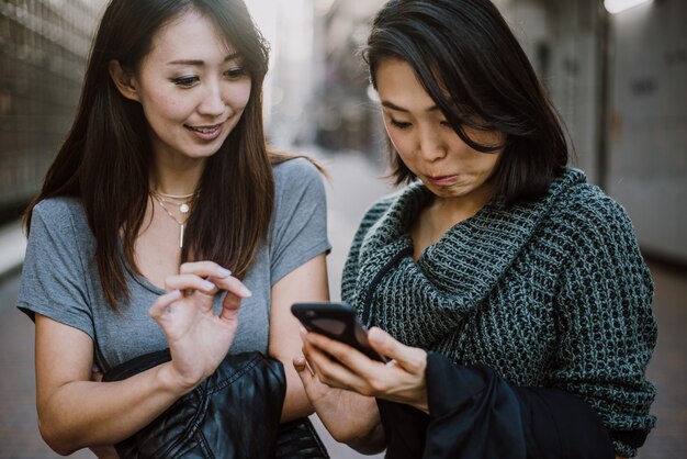 Twee Japanse vrouwen rond in Tokyo overdag. Winkelen en plezier maken