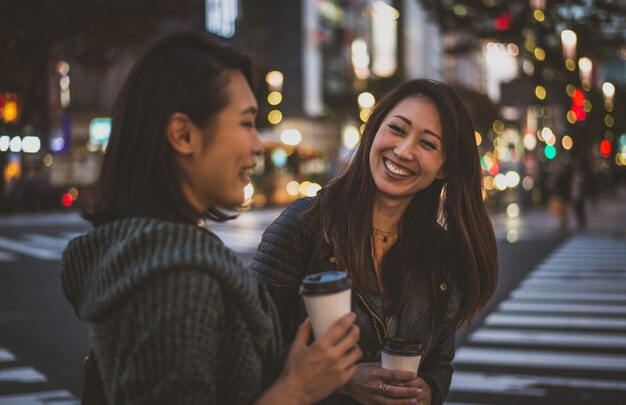 Twee japanse vrouwen rond in tokyo overdag. winkelen en plezier maken