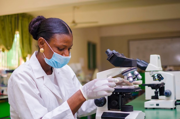 Twee jonge afrikaanse gezondheidszorgonderzoekers die in een biowetenschappelijk laboratorium werken aan de genezing van de uitbraak in de samenleving.