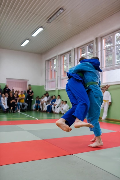 Twee jonge atleten tonen hun judokunsten voor de coaches