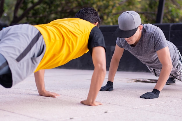 Twee jonge atletische mannen die samen push-ups doen