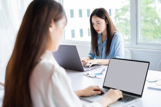 Twee jonge Aziatische vrouwen zijn gefocust op werken