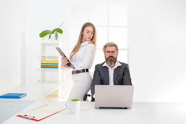 Twee jonge bedrijfsmedewerkers die met laptop op kantoor samenwerken