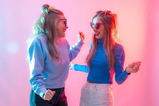 Twee jonge blonde blanke vrouwen die dansen in een nachtclub en veel plezier hebben met dansen