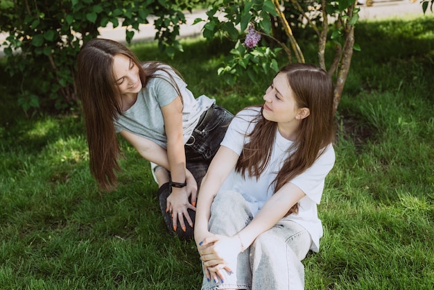 Twee jonge gelukkige tienermeisjes die plezier hebben in het park op een zomerdag. Vrouwelijke vriendschap. Zachte selectieve focus.