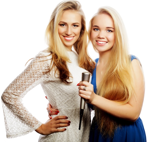 Twee jonge hipster blonde meisjes zingen, op witte achtergrond