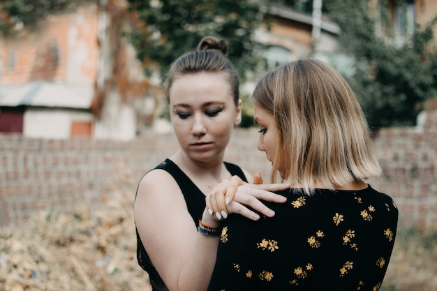 Twee jonge lesbiennes meisjes buiten knuffelen.