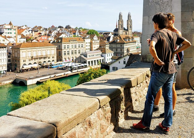 Twee jonge man kijken naar Limmatquai in Zürich, Zwitserland. Grossmunster op de achtergrond