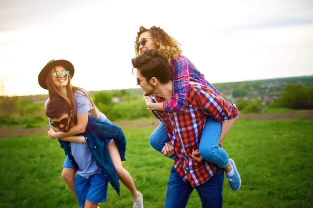 Twee jonge mannen die hun vriendinnen meeliften Groep vrienden genieten van een feestje