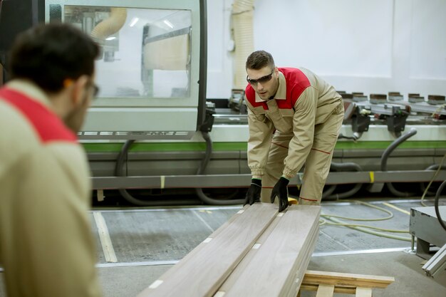 Twee jonge mannen die in de meubelfabriek werken